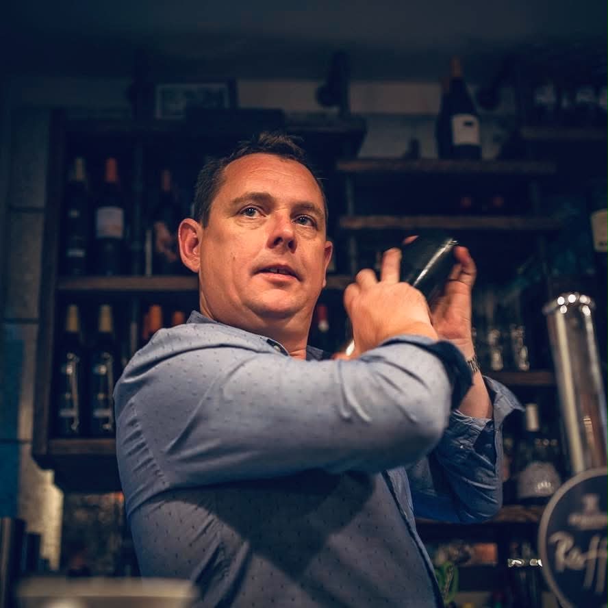 Ed Rafferty shaking a cocktail behind the bar