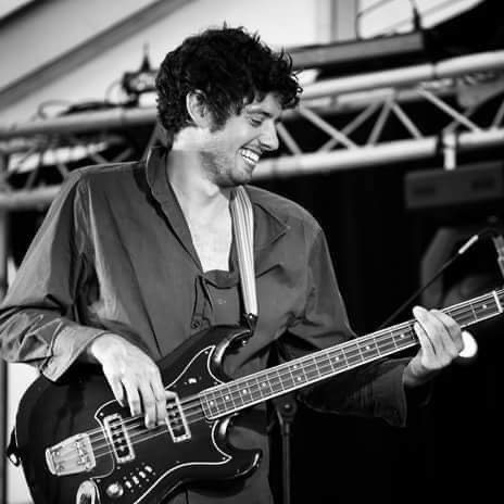 Mark Wilson on stage, laughing as he plays bass