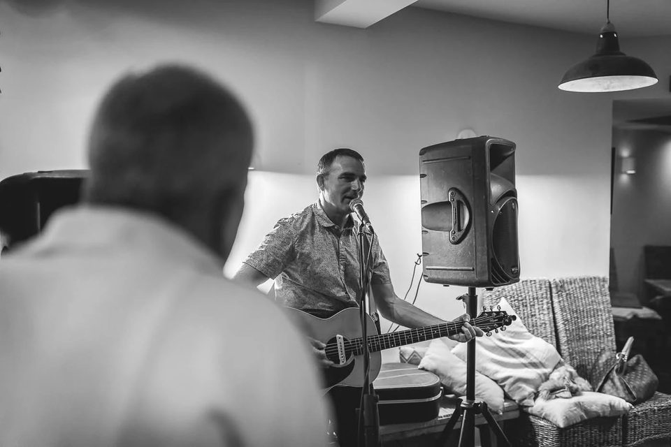 Steve Panter singing with an acoustic guitar